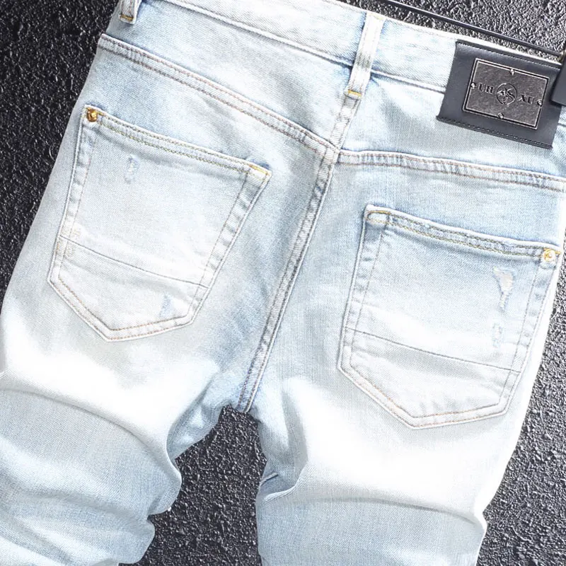 Israeli designer's fashionable new light blue men's jeans with cracks, pleats, nostalgic stretch and slim fit casual pants