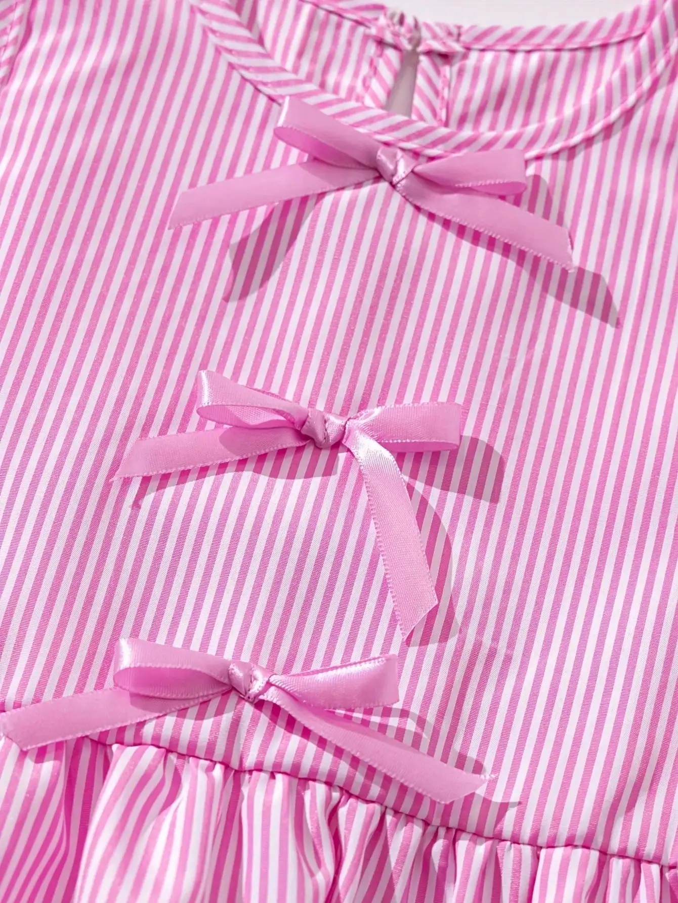 Modisches zweiteiliges Set für Mädchen: rosa-weiß gestreifter Rundhalspullover mit Schnürung, Schleife und Rüschenrand + rosa gestreifte Schmetterlings-Shorts. – Detail 6