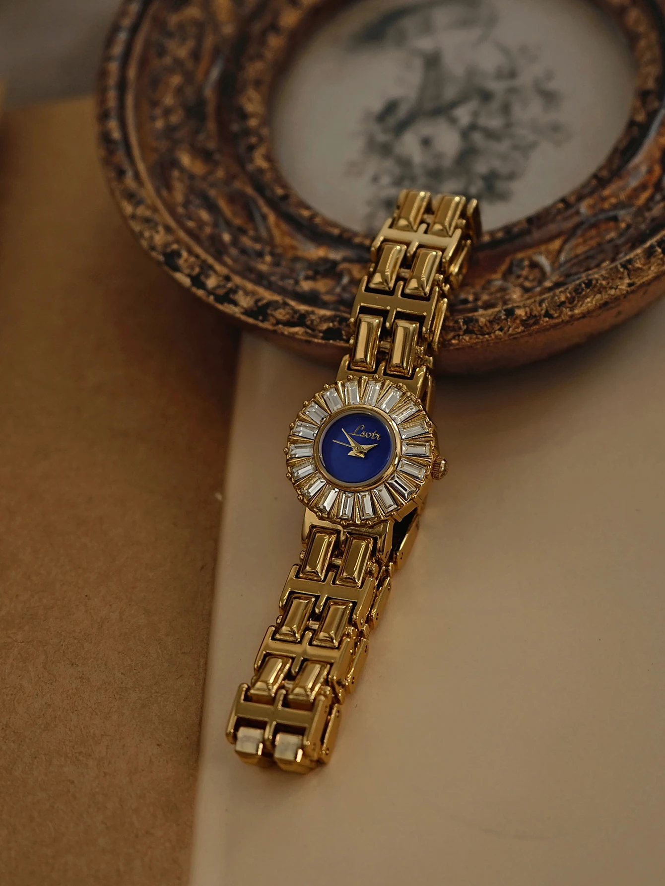 

1 новая модель золотых женских кварцевых часов, изысканных и элегантных, с прямоугольными стразами и синим перламутровым циферблатом.