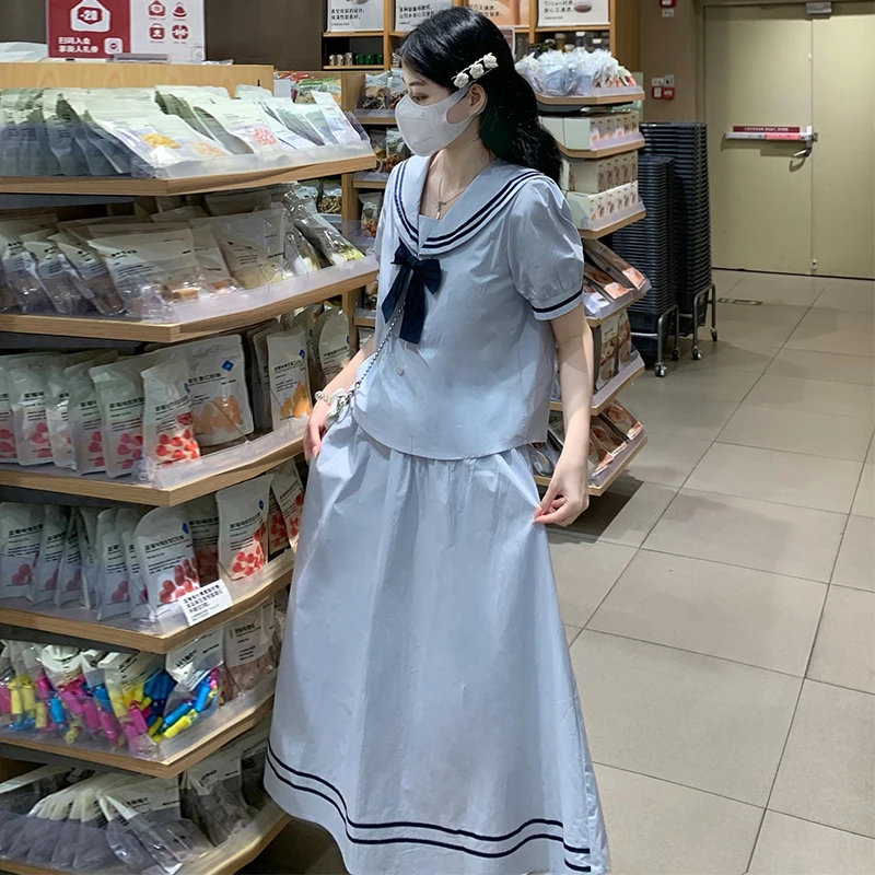 Letni granatowy strój marynarski damski lub zestaw marynarski dwuczęściowy, podkreślający figurę, młodzieżowy, spódnica, damski komplet.