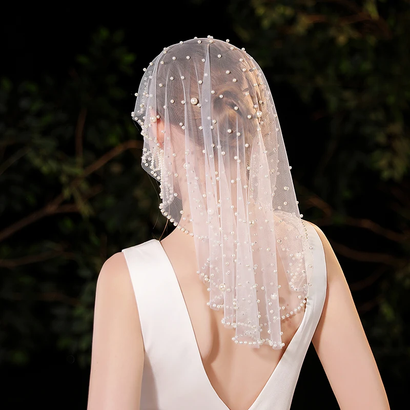 

A white elegant bridal veil adorned with simulated pearls suitable for women's weddings (excluding earrings)