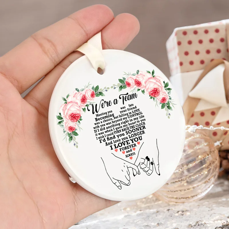 Un singolo ornamento in ceramica con le parole "Siamo una squadra", abbellimenti da parete in stile tradizionale, ideali per regali natalizi.