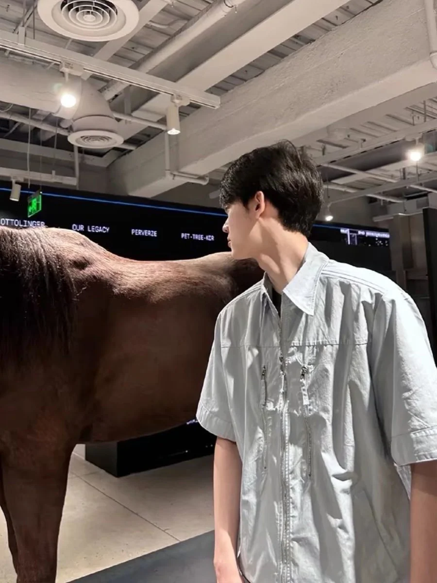 قميص رجالي كاجوال صيفي فضفاض بياقة مسطحة وأكمام قصيرة بخمسة أرباع طول الأكمام بلون أزرق فاتح وسحاب على الكتف