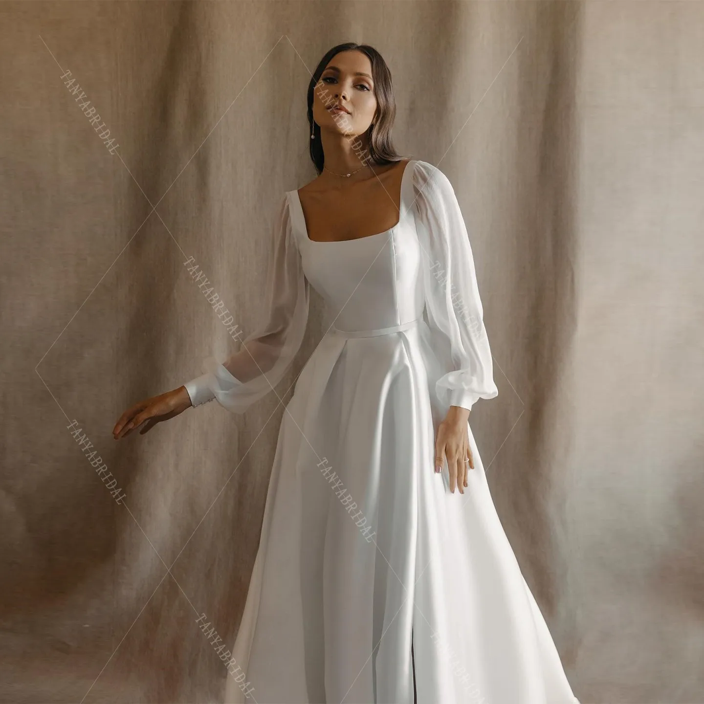 ชุดแต่งงานผ้าซาตินคอเหลี่ยม แขนยาว ทรงเอ ผ่าข้างสูง ชายกระโปรงยาวลากพื้น ดีไซน์หรูหรา