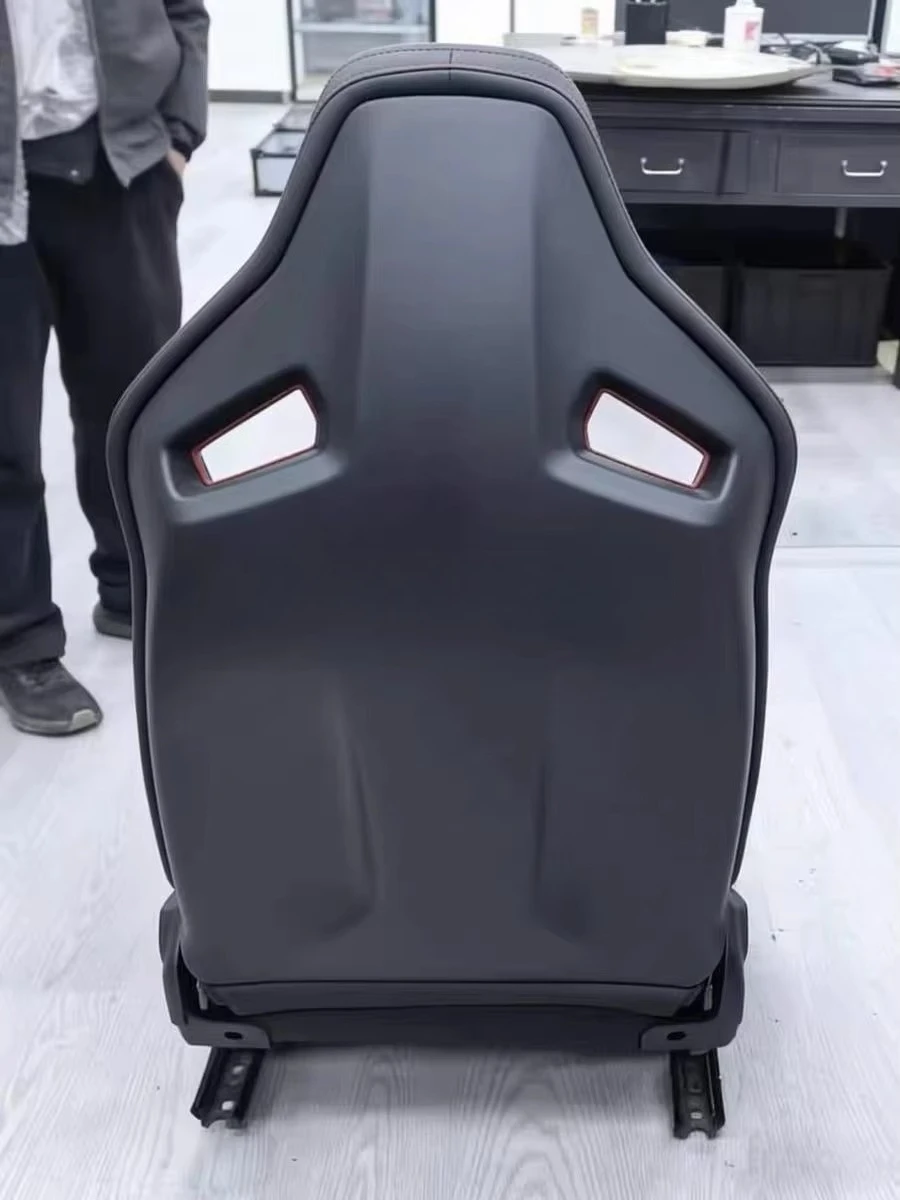 The B10 carbon fiber barrel seat, suitable for racing cars, features suede and red accents, and is inspired by racing cars.