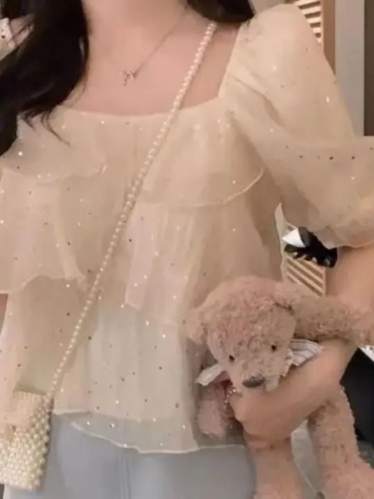 

Элегантная женская блузка с многослойным дизайном и эффектом «кейк-топ», квадратным вырезом и декоративными элементами, омолаживающая, красиво оформленная