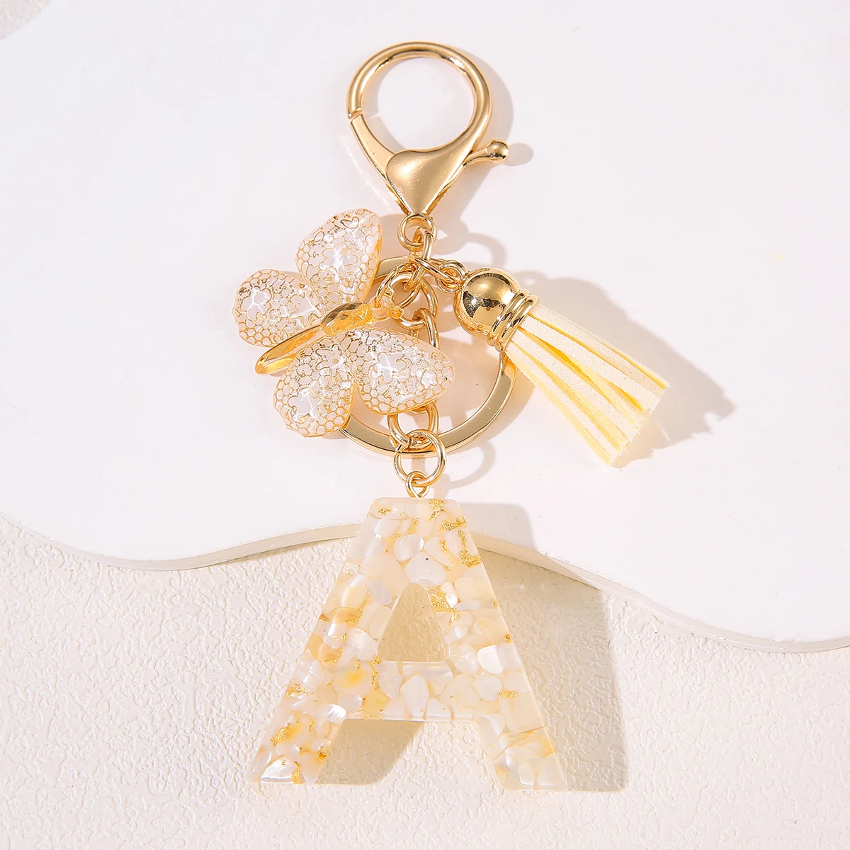 Porte-clés initial d'élégance mignon avec breloque papillon et pompon, porte-clés avec lettre cadeau pour la journée des femmes avec fermoir à homard pour sacs à main