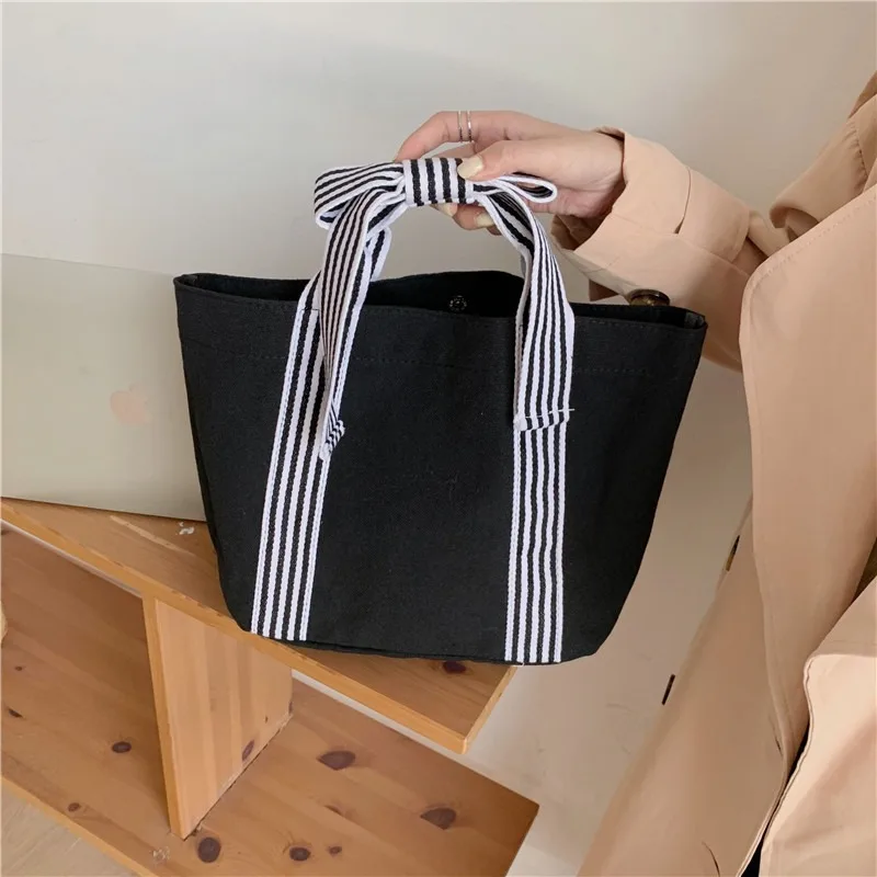 Bolso de lona negro neutro de moda simple para mujer con lazo, pequeño y fresco, con asa de mano.