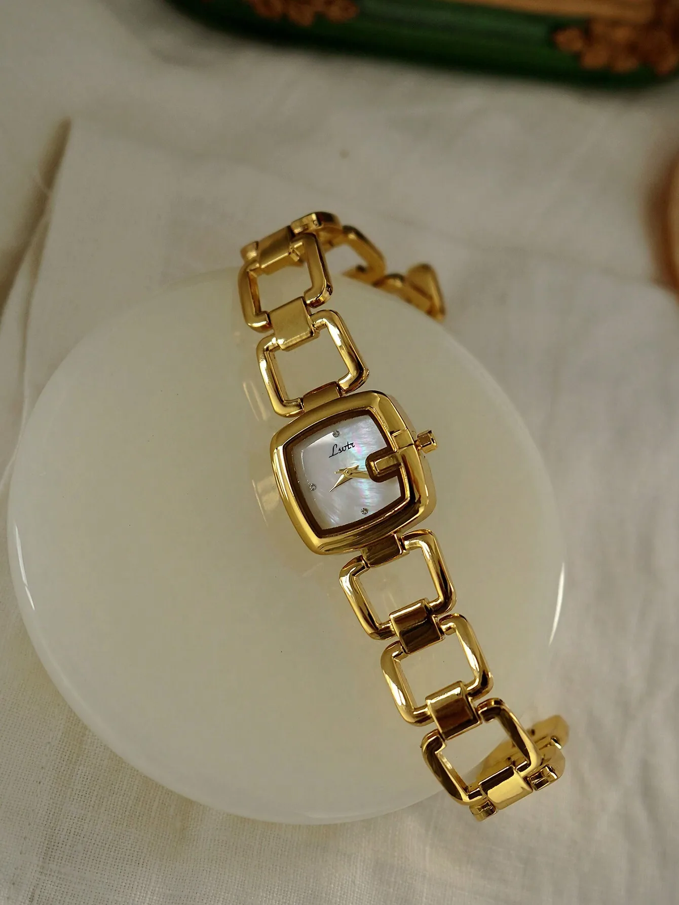 

Элегантные золотистые часы с квадратным циферблатом, перламутровой вставкой и браслетом-цепочкой.