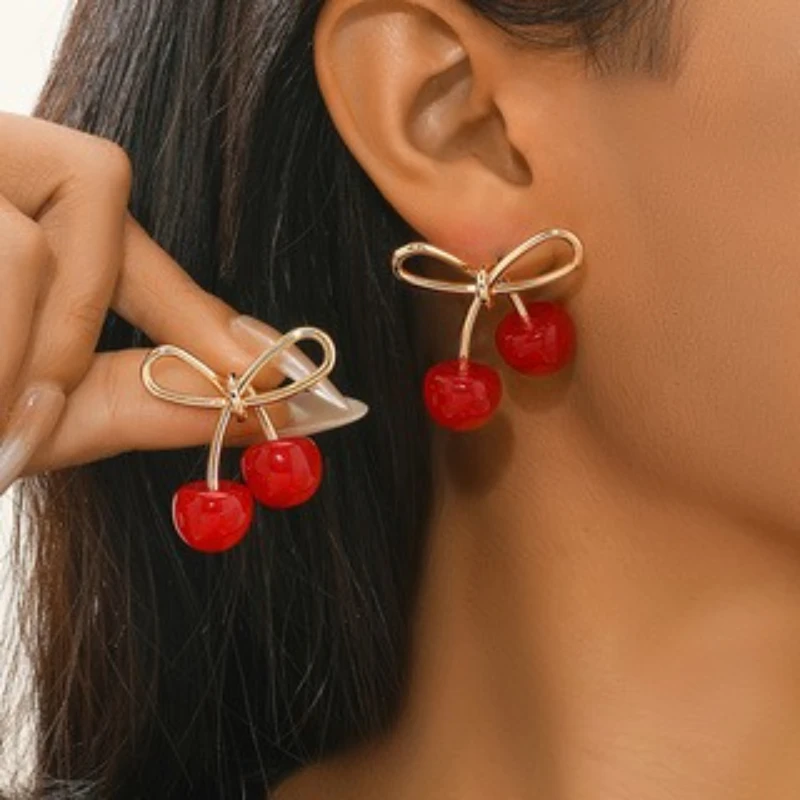 Los nuevos pendientes colgantes de cereza con lazo hueco creativo personalizado, tendencia de moda para mujer, cien con accesorios de joyería