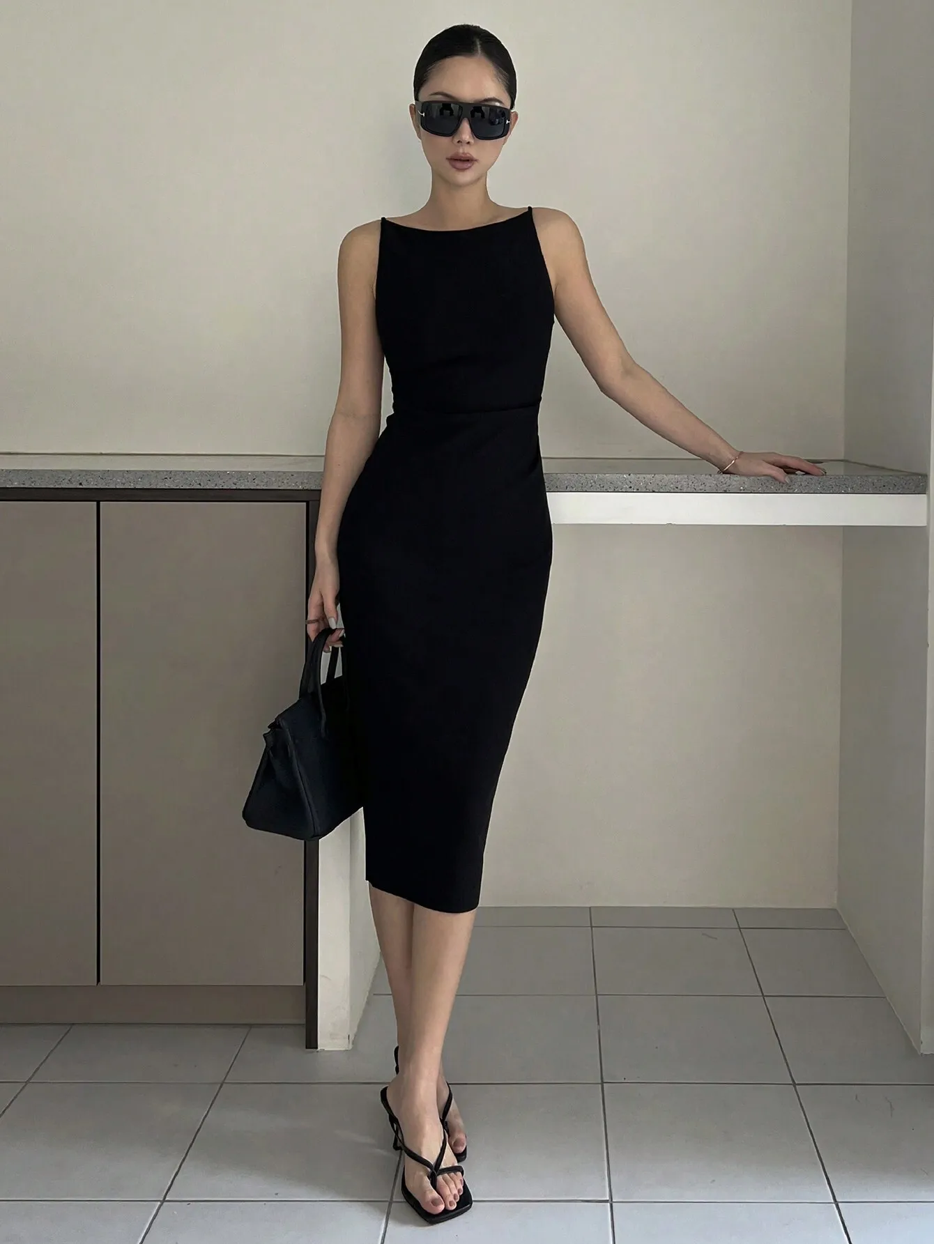 

Черное облегающее платье миди без рукавов с акцентом на талии и боковым разрезом