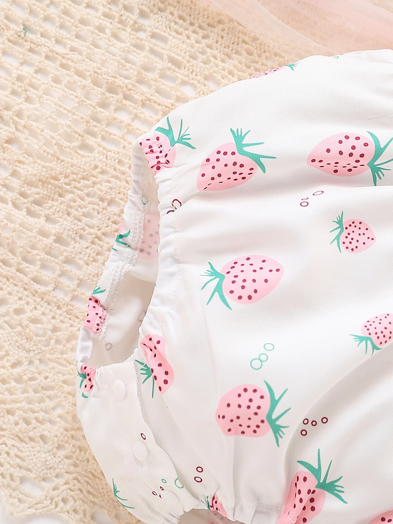 فتاة لطيفة في رومبير كاجوال بنمط الفراولة بالكامل، بما في ذلك ملحق القبعة، للصيف.