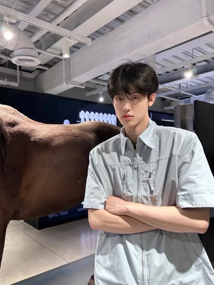 قميص رجالي كاجوال صيفي فضفاض بياقة مسطحة وأكمام قصيرة بخمسة أرباع طول الأكمام بلون أزرق فاتح وسحاب على الكتف