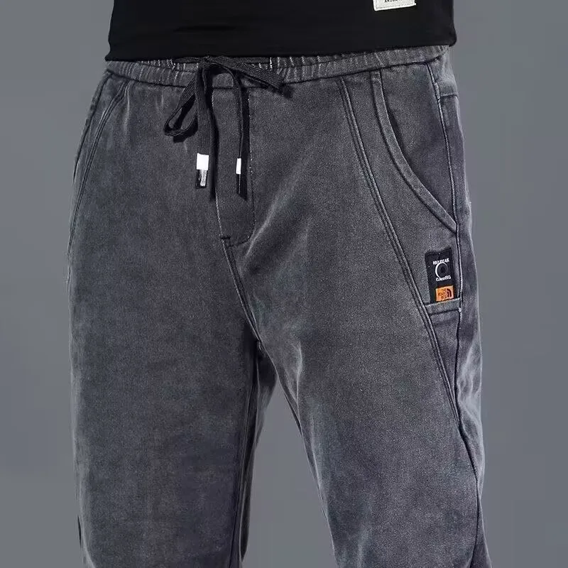 Jeans casual in vita elastica da uomo primavera nuovi pantaloni lunghi larghi a gamba dritta gioventù trendy tessuto denim blu resistente all'usura