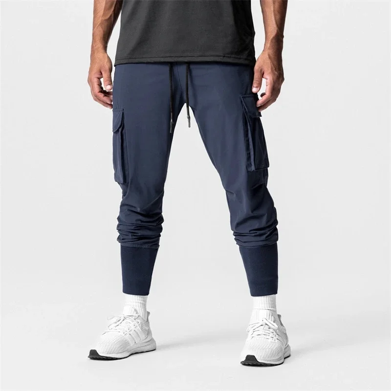 Pantalones deportivos de gimnasio para hombre, ropa de calle para fitness al aire libre, elásticos, con múltiples bolsillos, a la moda, novedad de