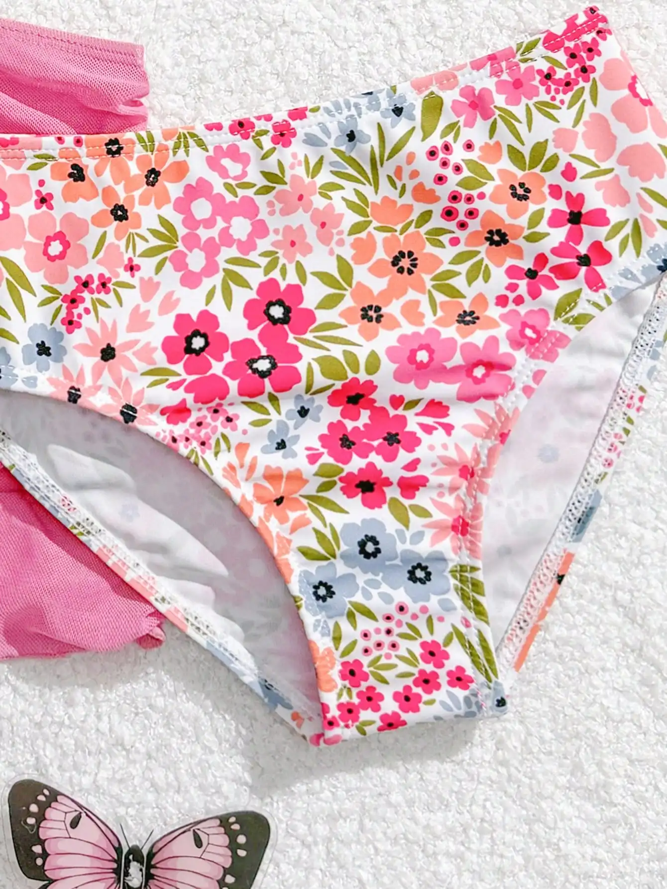 

Комплект из трех предметов: купальник с цветочным принтом и рюшами, а также юбка-парео для женщин