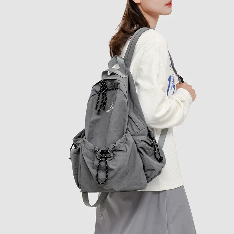 ไนลอนสีทึบความจุขนาดใหญ่กระเป๋าเป้สะพายหลังนุ่มกระเป๋าอเนกประสงค์หญิง 2025 คุณภาพสูง Air Cushion Strap กระเป๋าเป้สะพายหลังลําลองแบบนุ่ม