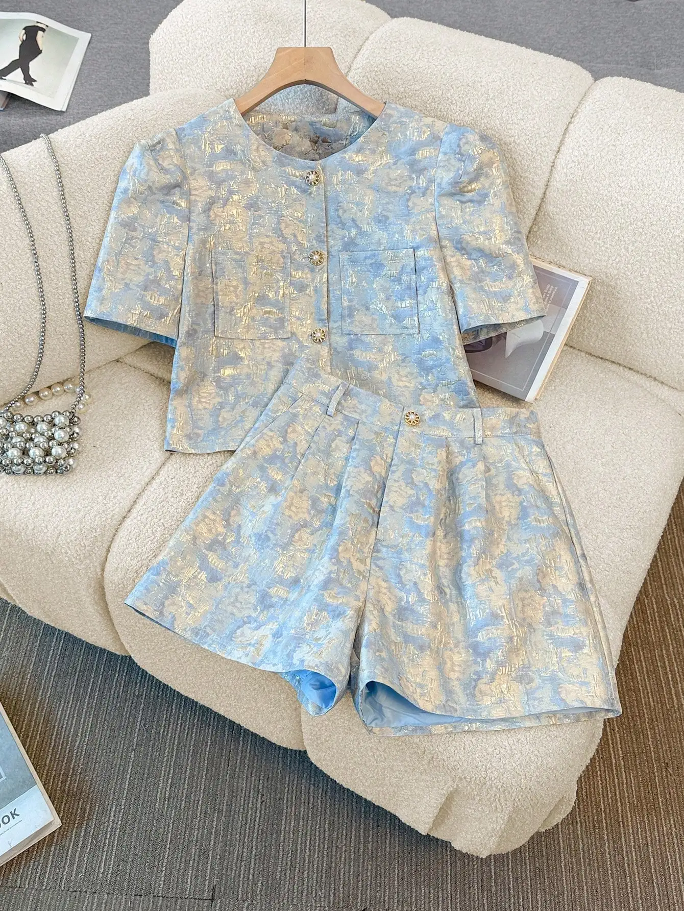 

Светло-голубой комплект из топа с короткими рукавами и плиссированных шорт с золотым принтом из жаккарда