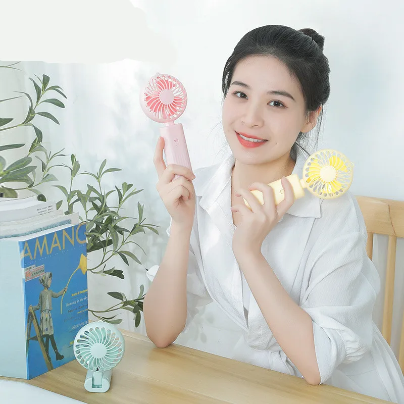 New foldable hand-held small fan Mini portable desktop fan Simple shape, strong wind speed, driven by two AA batteries