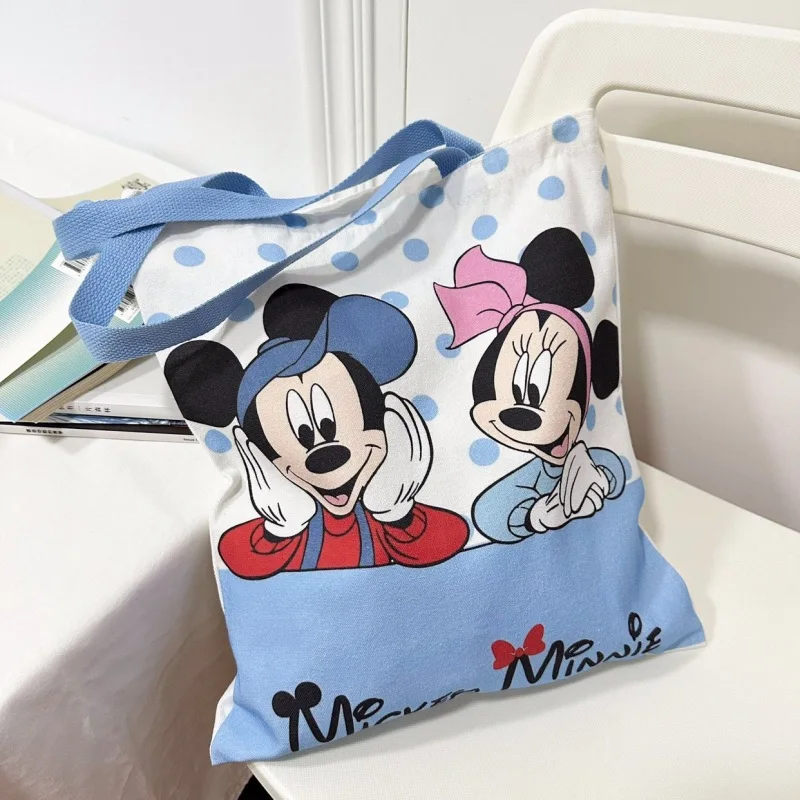 ใหม่ Kawaii Mickey Mouse ผ้าใบกระเป๋าอะนิเมะ Minnie Mouse อุปกรณ์เสริมกระเป๋าสะพายนักเรียนกระเป๋าเป้สะพายหลังการ์ตูนมือถือช้อปปิ้งกระเป๋า