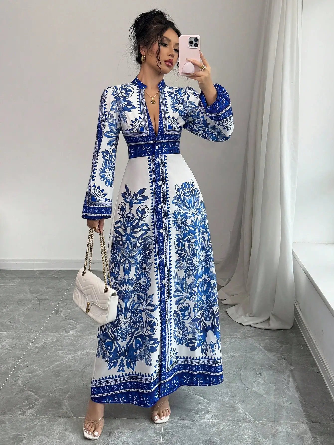 

Сине-белое платье макси с цветочным принтом, V-образным вырезом, на пуговицах и рукавами-колокол.