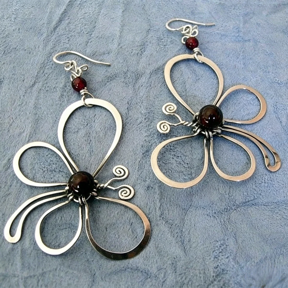 Lignes simples, en forme de fleur avec un centre constitué de pierres précieuses artificielles. Boucles d'oreilles pendantes pour femmes, idéales pour les rendez-vous et les soirées.