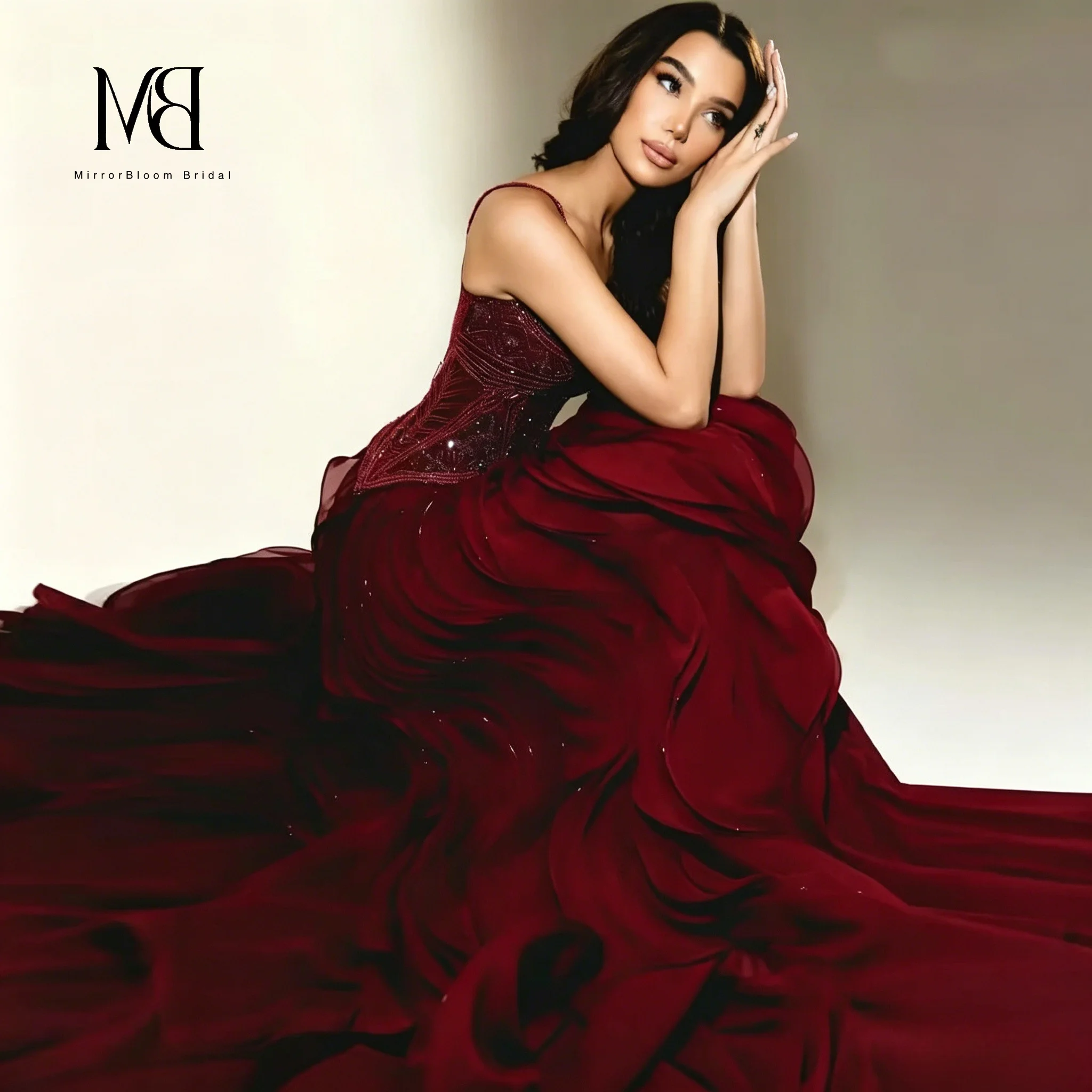 Red strapless sleeveless floor-length formal ball gown featuring a full voluminous skirt with petal-like details and beadwork