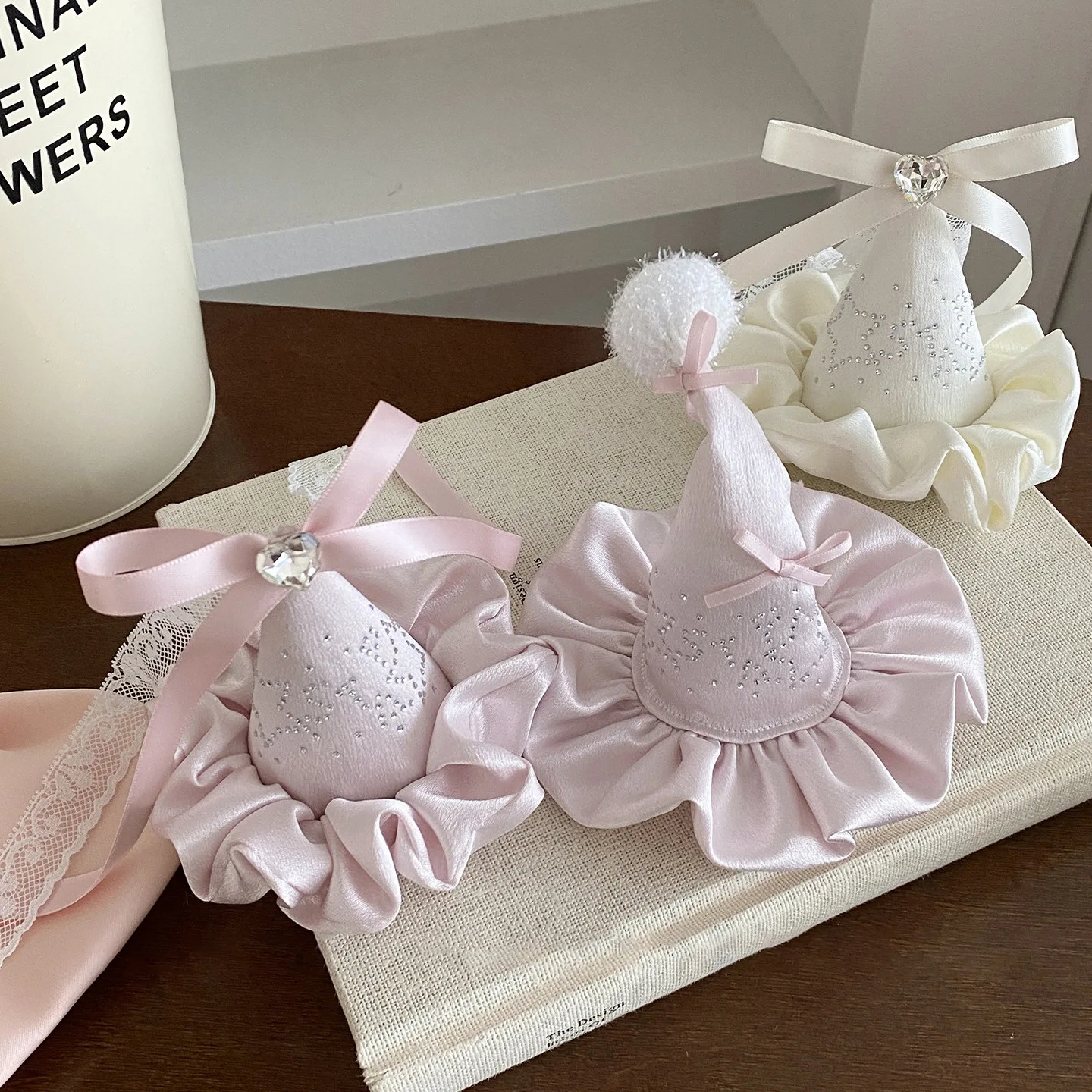 Cone-Shaped Hair Accessories with Ruffled Base — Faceted Gem Accent, Ribbon Bow, Two Color Variants on Textured Surface