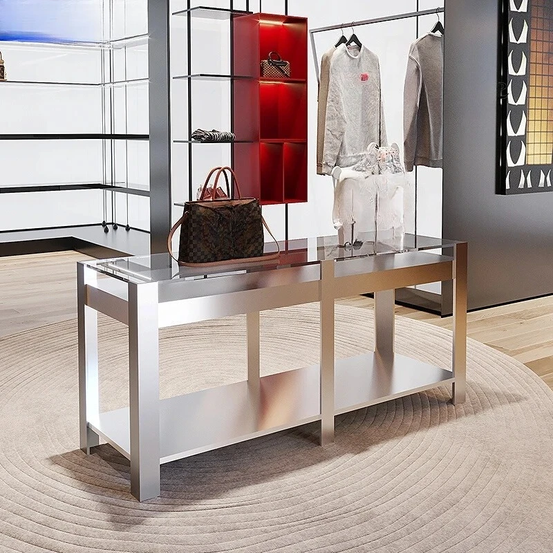 Stainless steel shoes and bags are placed in the middle of the Nakajima table in the clothing store. High and low display stands