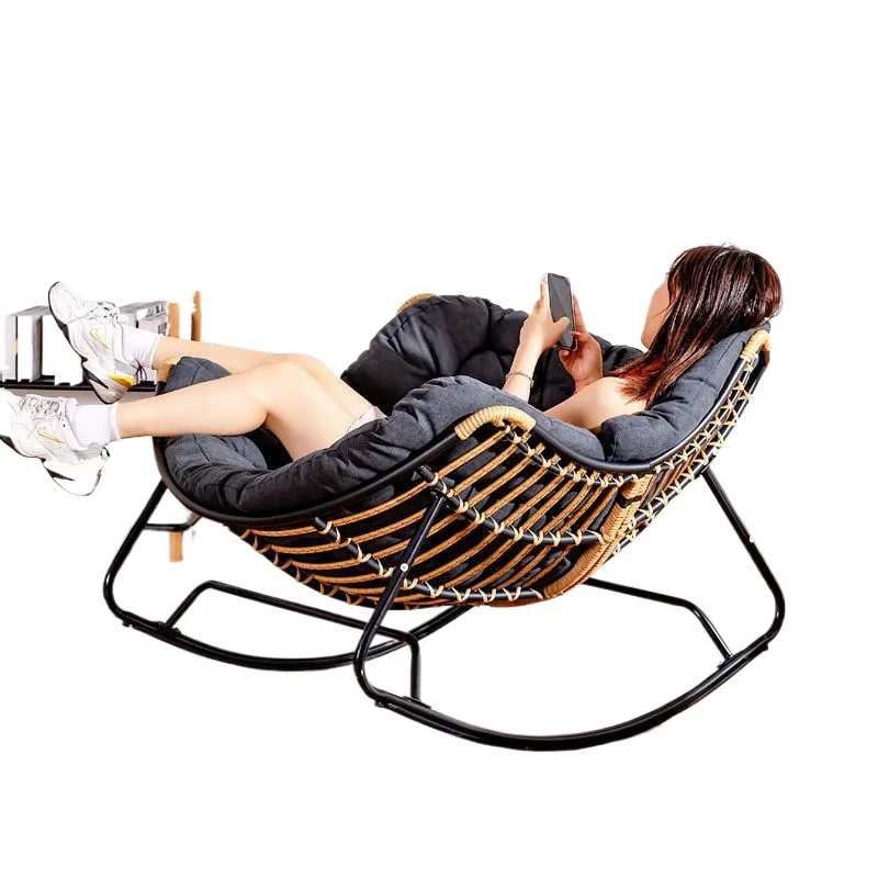 Person relaxing in the Nordic Rattan Rocking Chair
