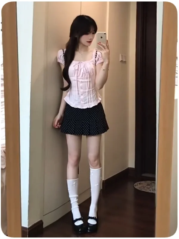 Conjunto de duas peças para mulheres: Camisa rosa com bolinhas e mangas bufantes e  saia preta com bolinhas, roupa de ver...