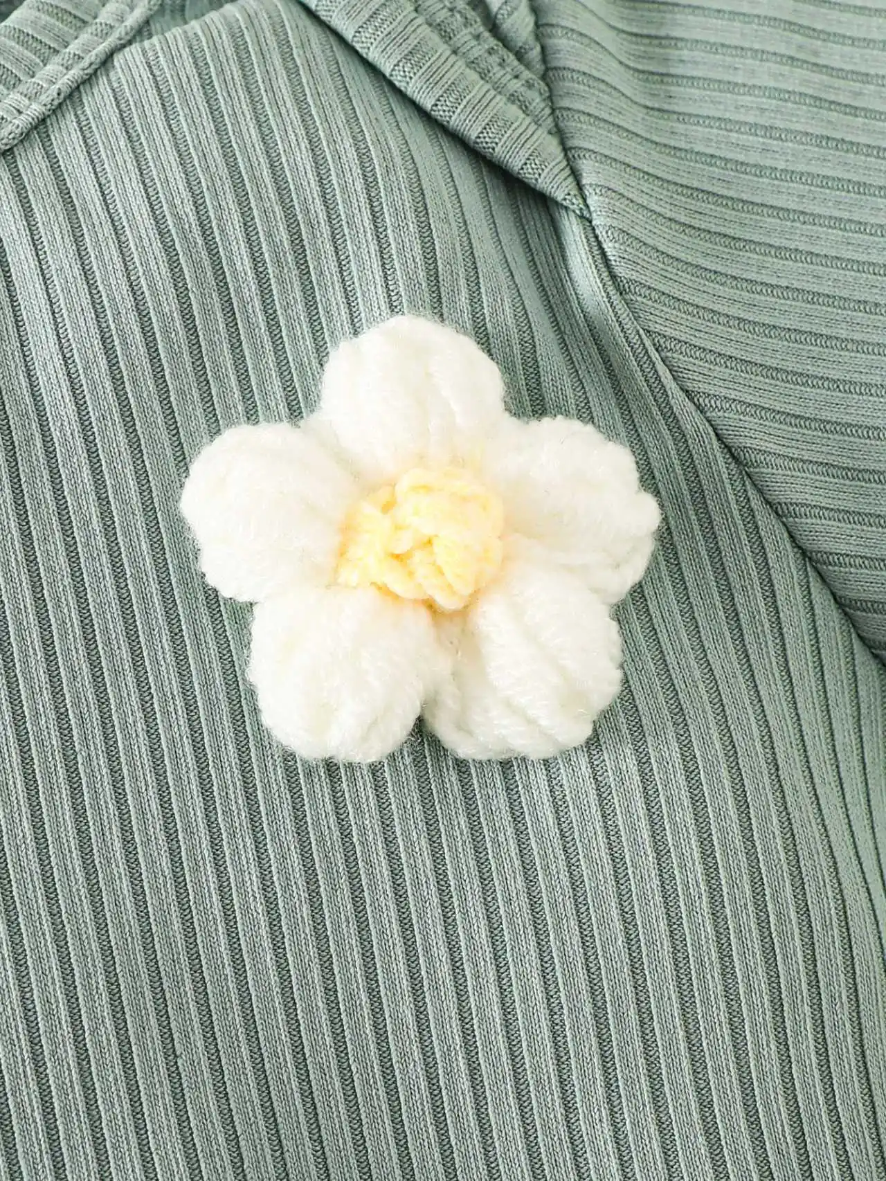 Grünes Set aus langärmligem Strampler mit Rundhalsausschnitt und kleinem Blumenmuster sowie einer langärmligen Stramplerhose mit süßem Blumenmuster für Babys. – Detail 4