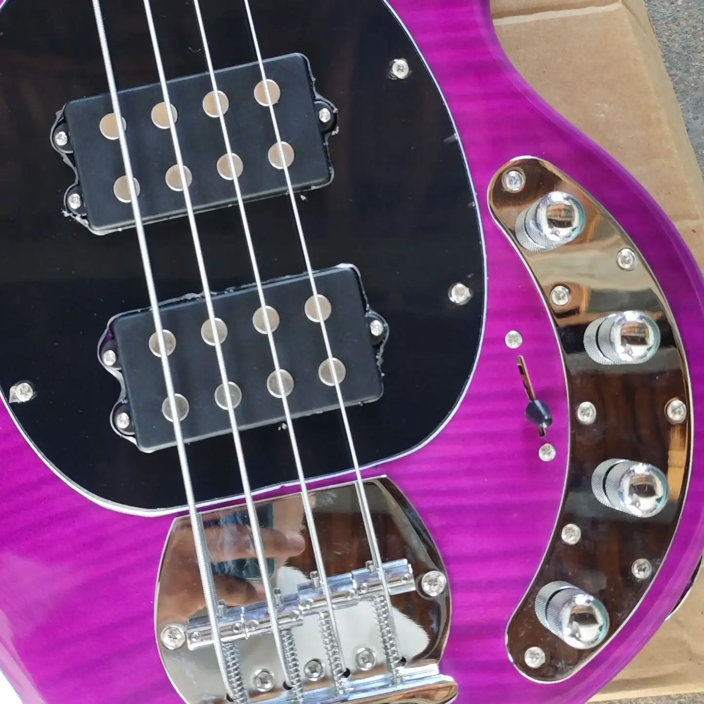 Pink four-string bass, full-body link, tiger-pattern veneer on the front, basswood piano body and rose wood fingerboard.