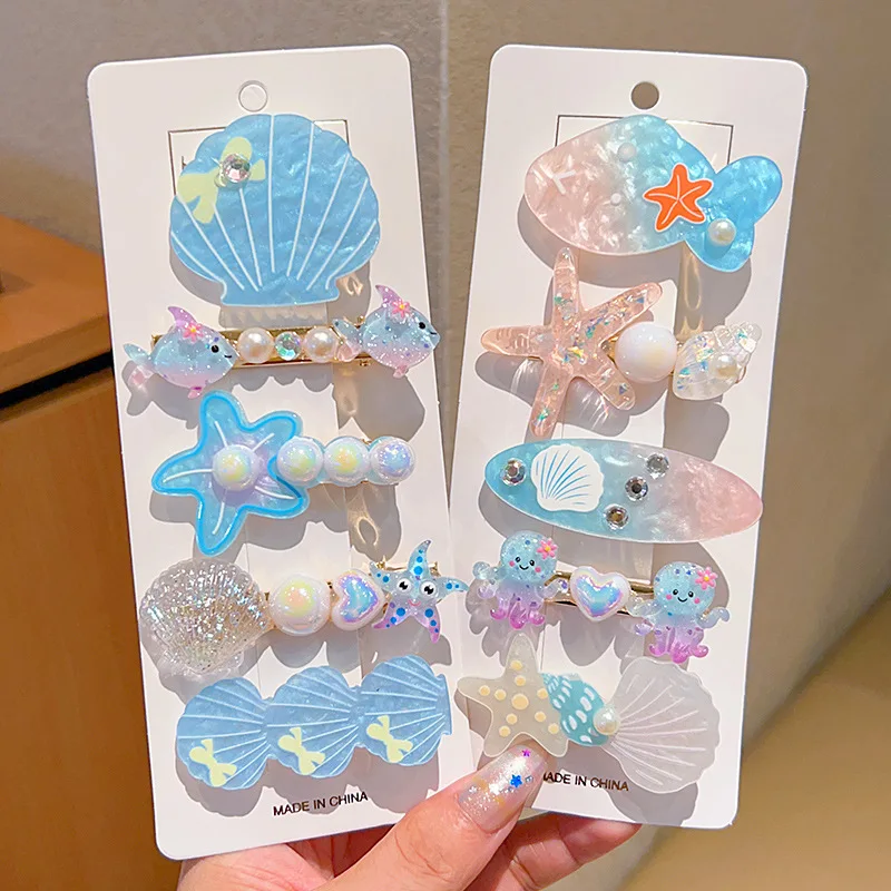 Multiple Decorative Items on Display Cards Shell-Shaped, Starfish-Shaped Marine Mammal-Shaped Elements with Iridescent Finish