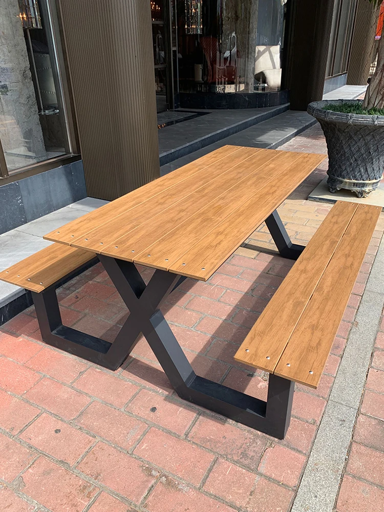 Long table and chairs outside the wrought iron long seat