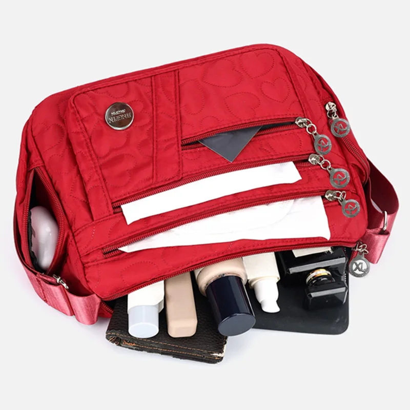 Schicke, verzierte Damen-Umhängetasche für den täglichen Pendelverkehr. Stilvolle, leichte, lässige Nylontasche mit Herzdetail und mehreren Taschen – Detail 4