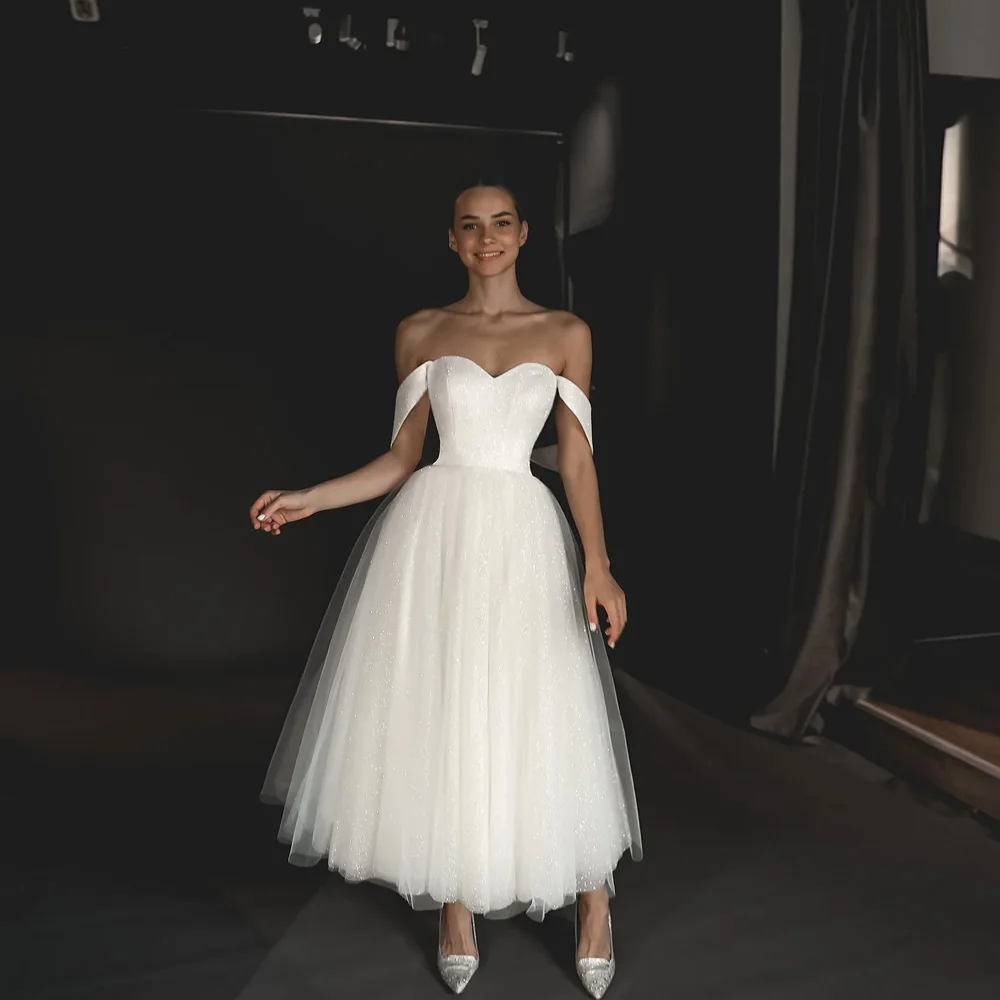 Eleganckie białe suknie ślubne Off the Shoulder bez rękawów świecące suknie ślubne A-Line Tea-Length Tulle فساتين مناسبة الب لب