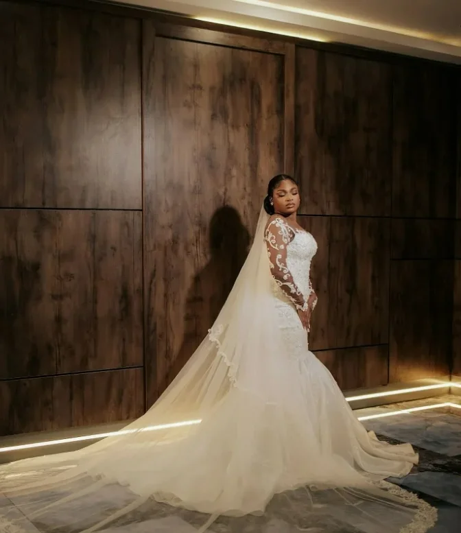 Suknia ślubna syrena z przezroczystym dekoltem, błyszczącymi aplikacjami, koralikami, długimi rękawami, plus size, w stylu rustykalnym.