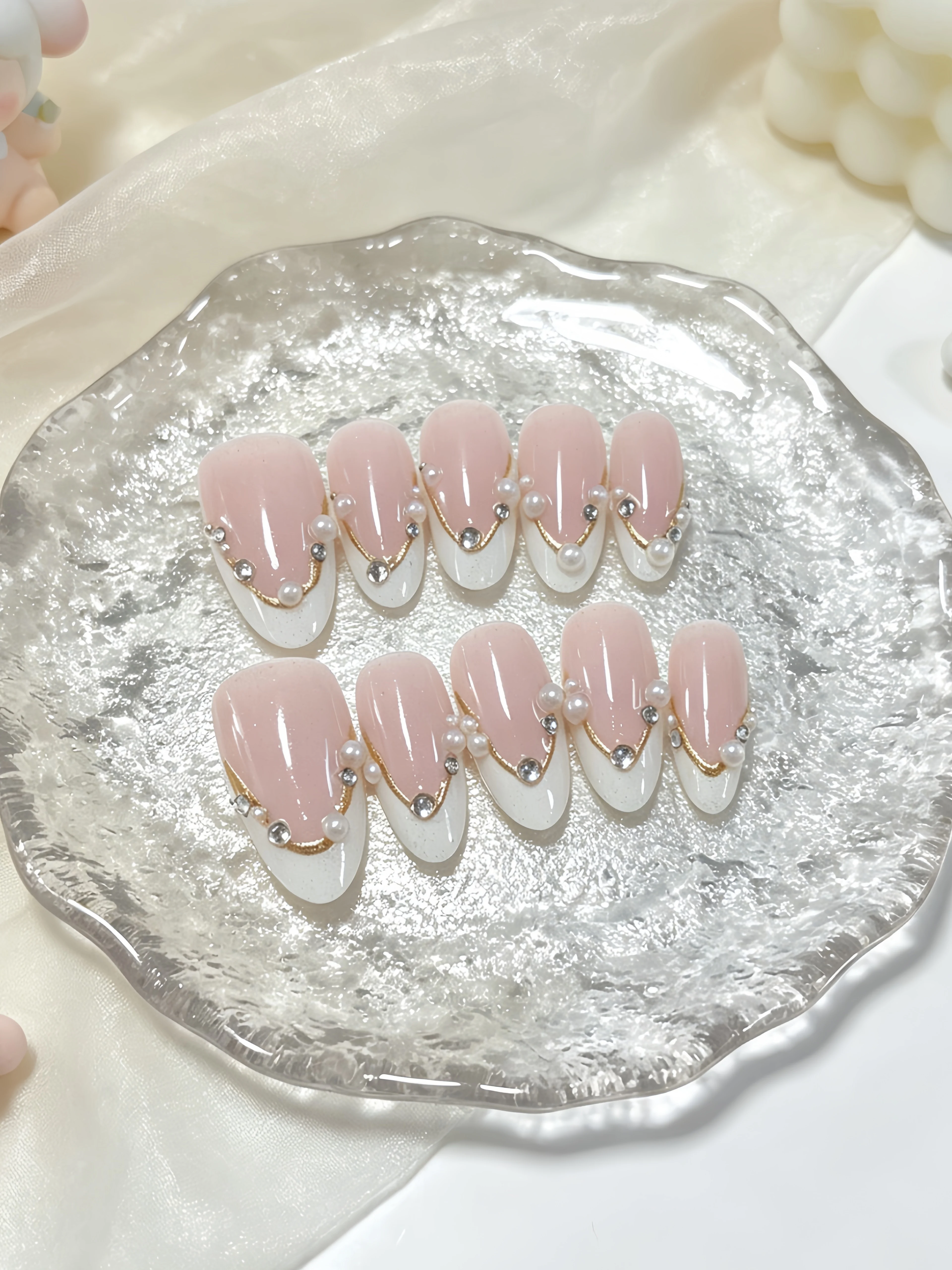 10 ongles courts en forme d'amande, aux couleurs principales rose nude et blanc laiteux, dans un style léger, luxueux et minimaliste. Autocollants pour ongles avec des éléments de points perlés de style français à bords dorés, adaptés aux étudiants, aux employés de bureau, aux femmes mûres et aux femmes intellectuelles pour les études quotidiennes, le lieu de travail, le bureau, la vie universitaire, les occasions sociales légères, le thé de l'après-midi et les rendez-vous. Faux ongles à coller, comprenant une colle gelée et une lime à ongles