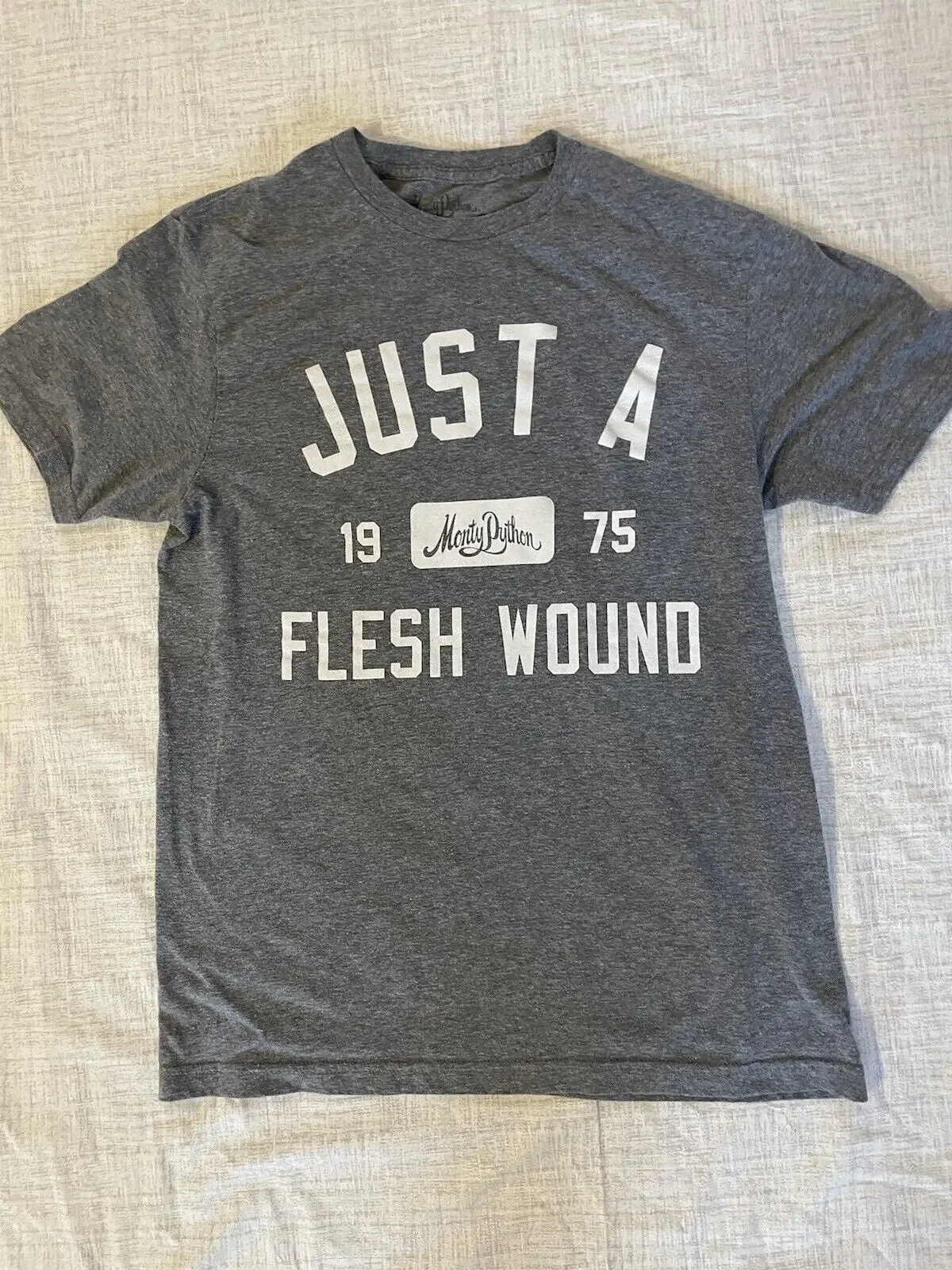 تي شيرت مونتي بايثون JUST A FLESH WOUND للرجال egyôs M مزيج القطن الرسمي باللون الرمادي #1