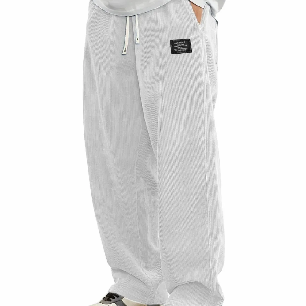 Novas calças compridas confortáveis de outono masculinas europeias, calças casuais de tecido de veludo com logotipo solto