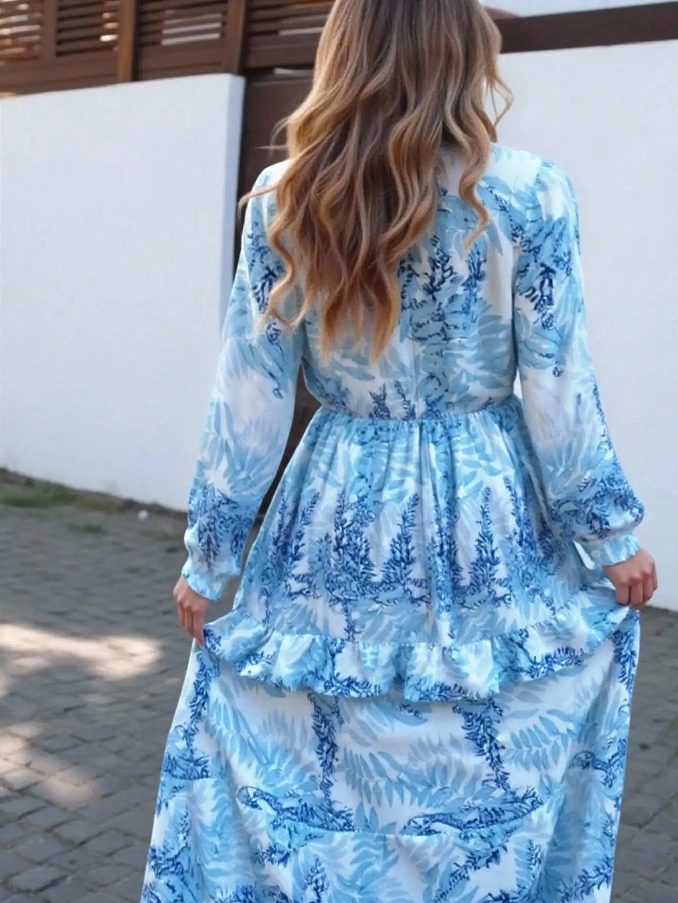 Damska niebieska sukienka maxi w kwiaty z dekoltem w serek, wycięciami i falbankami na rękawach, idealna na wakacje na plaży.