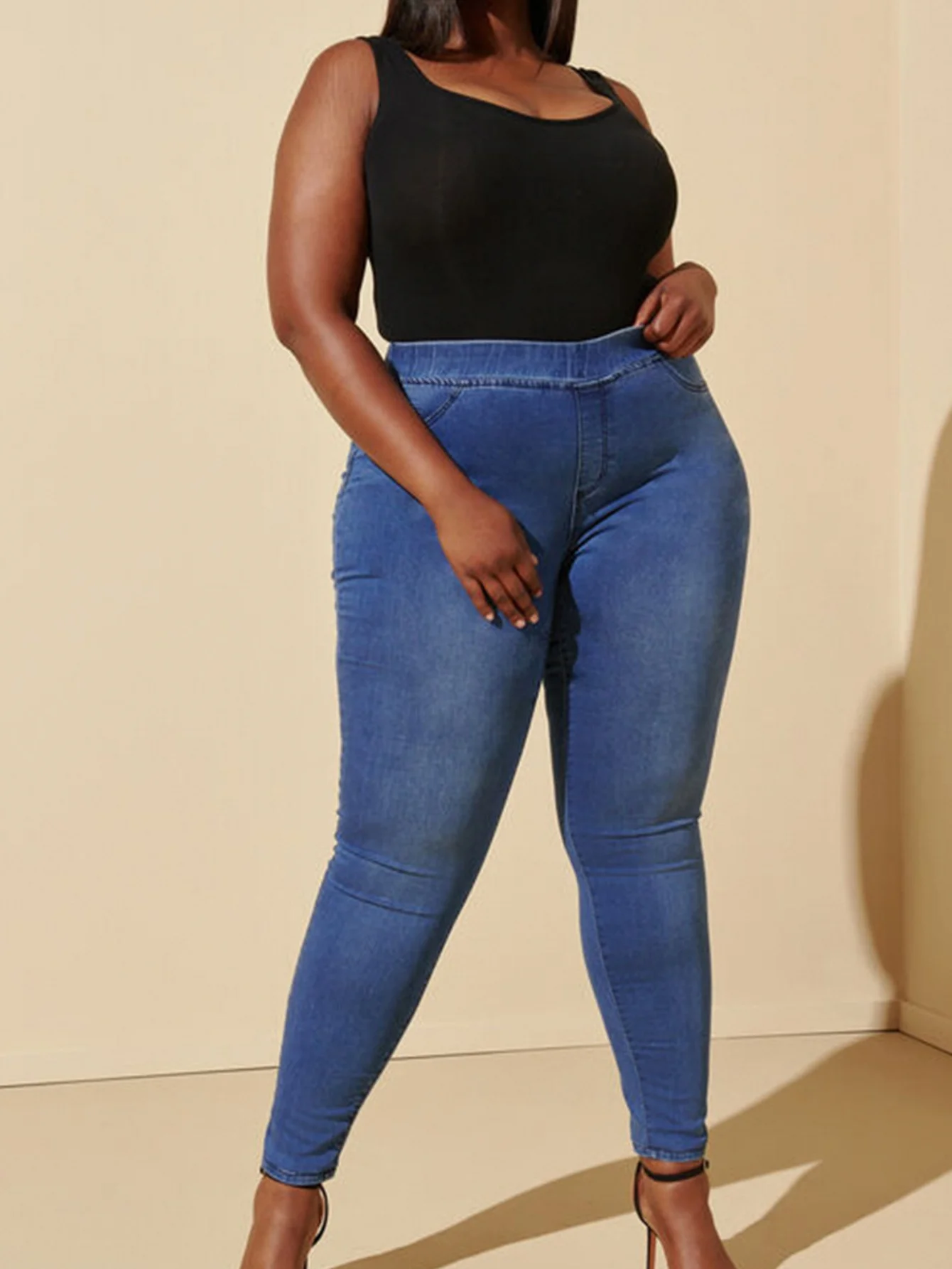 Dżinsy plus size, codzienne, elastyczne, z niebieskiego denimu, z gumką w pasie, o długości cropped, odpowiednie dla kobiet w okresie wakacji.