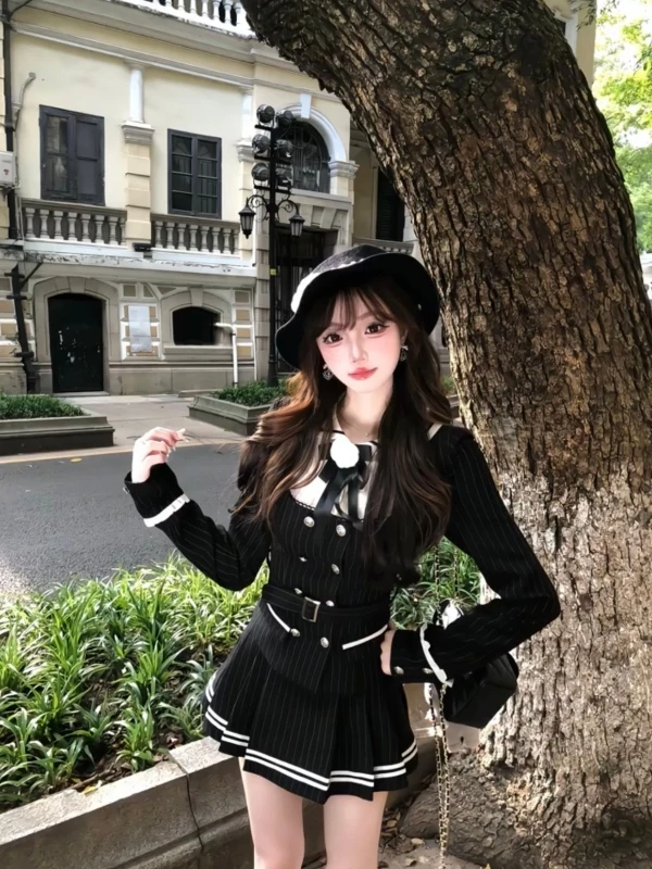 

Комплект из двух предметов: топ с высокой талией в клетку, контрастными вставками и двойной пуговицей, а также юбка в полоску в стиле колледж. Модный ансамбль.