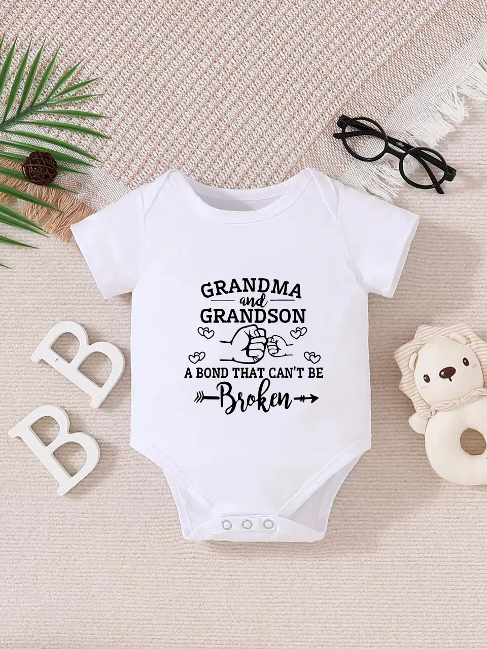 Playful letter-printed baby short-sleeve triangle bodysuit. Button closure for easy dressing, machine washable
