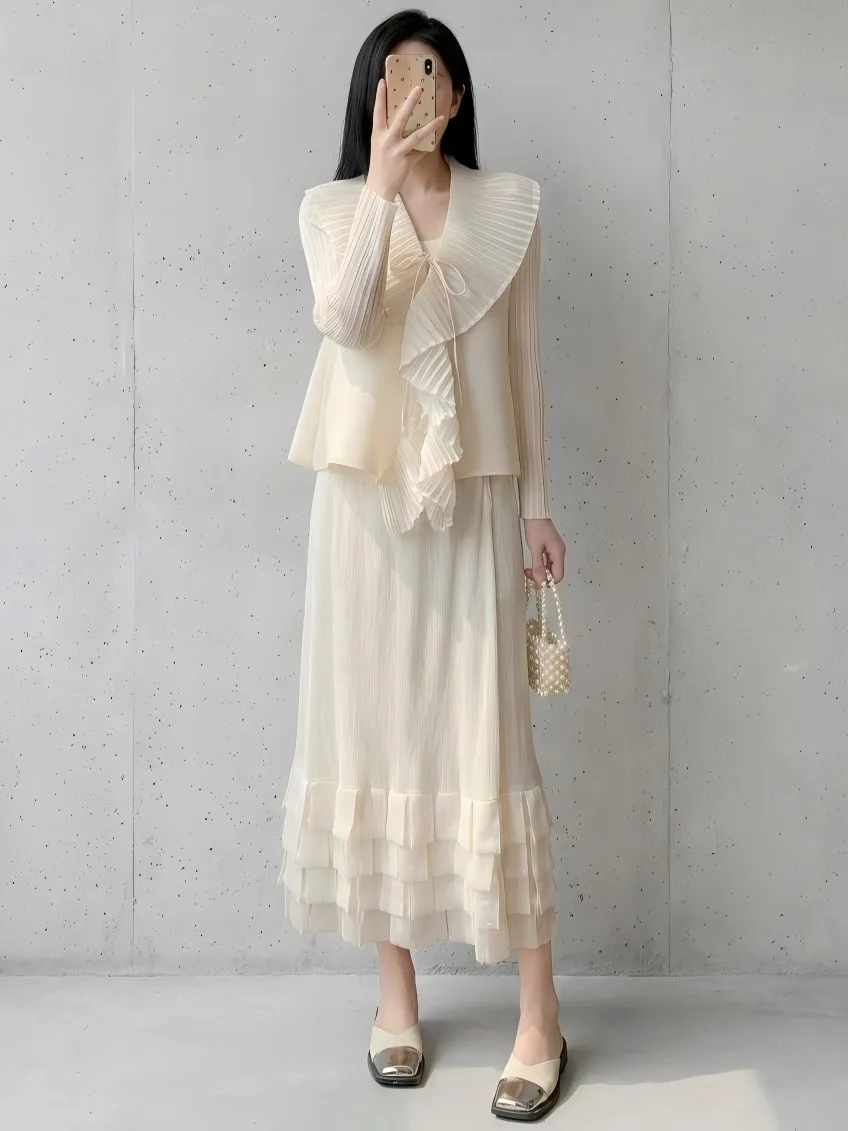 A two-piece set featuring a textured cardigan top and a ruffled tiered skirt, exuding an elegant and sophisticated style.