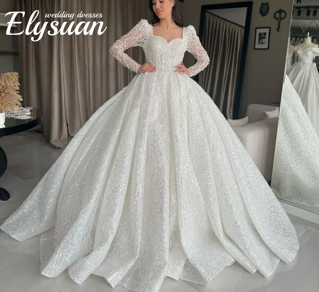 Gaun Pengantin Model Ball Gown Berkilau dengan Aksen Sweetheart, Lengan Panjang, Aplikasi Manik-Manik, dan Renda