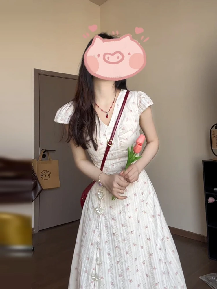 เดรสยาวทรงเอลายดอกไม้สีขาว คอวี สำหรับผู้หญิง ฤดูร้อน 2025 รุ่นใหม่ สไตล์ชายหาด เอวสูง ผ้าฝ้าย หวาน สไตล์เดรสชายหาด