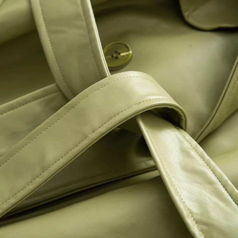 เสื้อโค้ทกันลมหนังยาวสีพื้นทรงหลวมประดับเข็มขัดที่ไหล่  คอลเลคชั่นฤดูใบไม้ร่วงใหม่สำหรับผู้หญิงจาก KEYANKETIAN