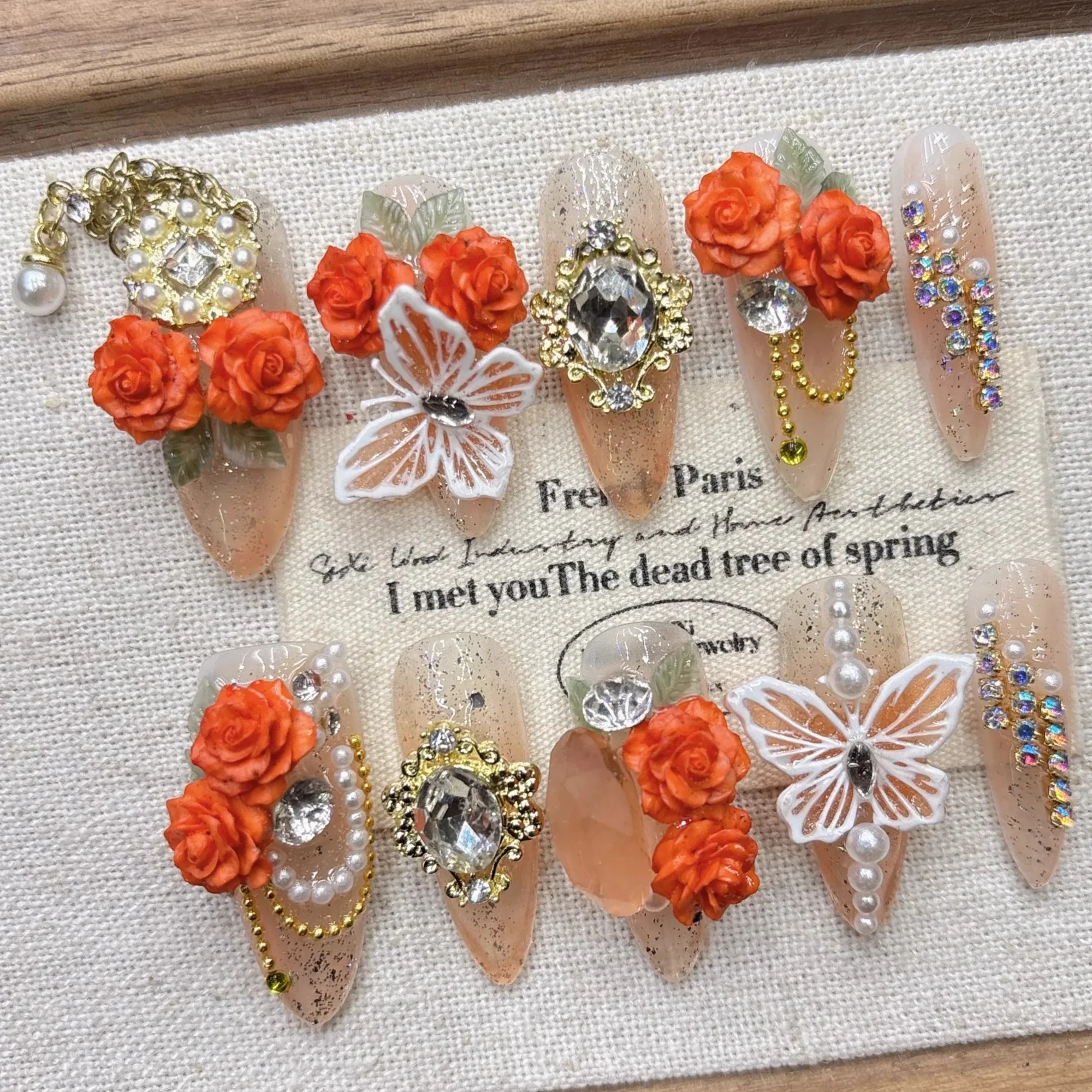 

Красивые накладные ногти во французском романтическом стиле с декором из сплавов, кристаллов, жемчуга и цветов из смолы. Элегантный и гламурный дизайн для вечеринок.